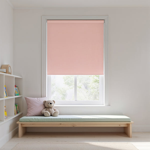 Pink roller blind in a window with a wooden bench and teddy bear in a room.