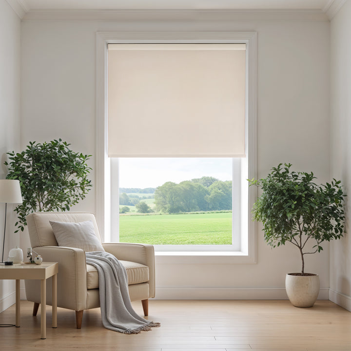Living room with beige armchair, side table, and large window with beige roller blind.