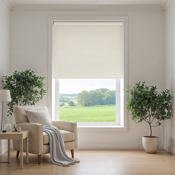 Living room with a beige armchair, side table, and large window with a view of greenery.