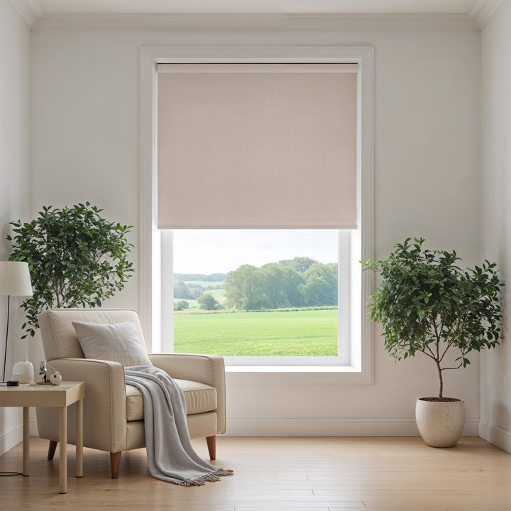 Living room with beige armchair, side table, and large window with stone beige roller blind.