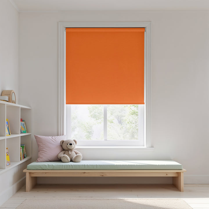 Orange roller blind on a window with a wooden bench and teddy bear in a room.